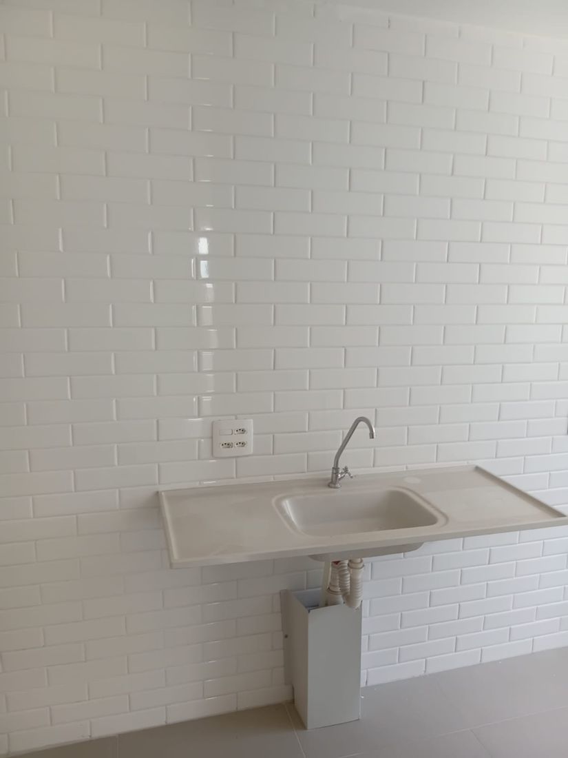 Cozinha com pia e parede de azulejo